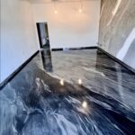 Galerija: Soba s črno-belo epoksi smolo na tleh in marmornato steno.