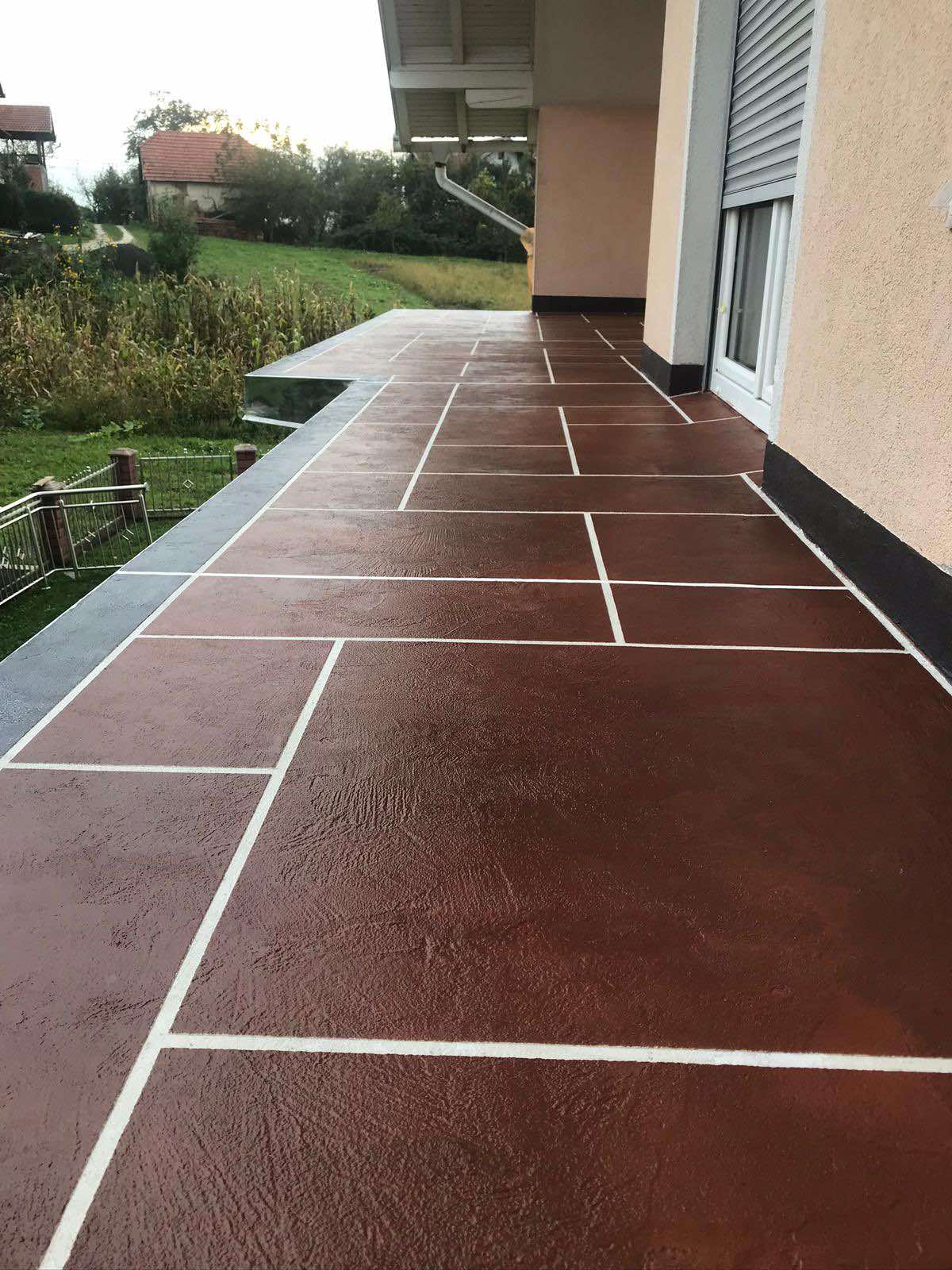 Terasa iz mikrocementa s pravokotnimi vzorci. Glavna barva je rjava.